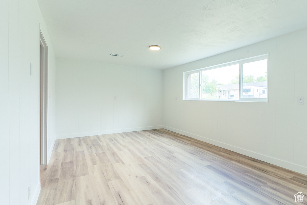 Unfurnished room featuring light wood-style flooring, baseboards, and visible vents