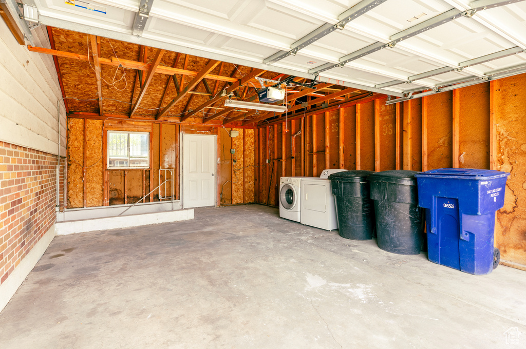 Garage with washing machine and clothes dryer and a garage door opener