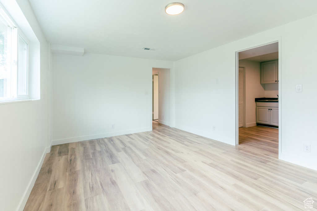 Unfurnished room with light wood finished floors and baseboards