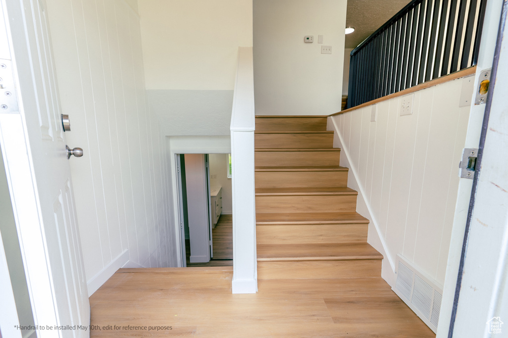 Staircase with visible vents and wood finished floors