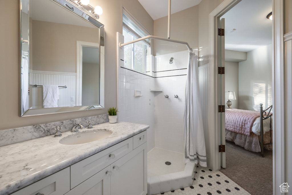 Bathroom featuring vanity, ensuite bath, and a shower stall
