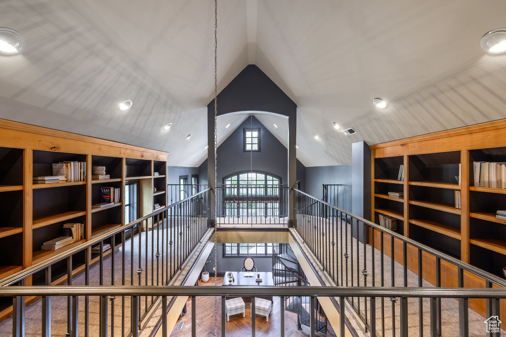 Interior space with visible vents, an upstairs landing, and high vaulted ceiling
