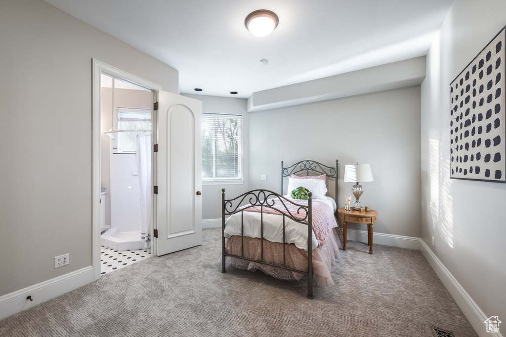 Bedroom featuring ensuite bathroom, carpet flooring, and baseboards