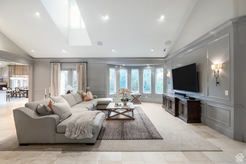 Living room with a wealth of natural light, a decorative wall, and high vaulted ceiling