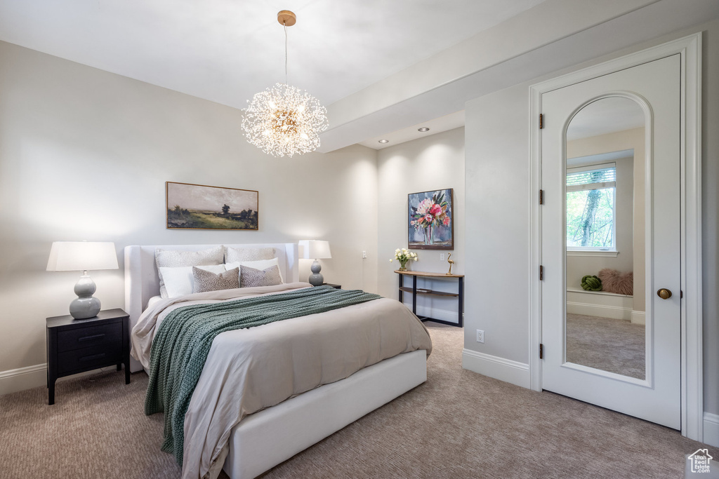 Bedroom with baseboards, carpet flooring, and a chandelier