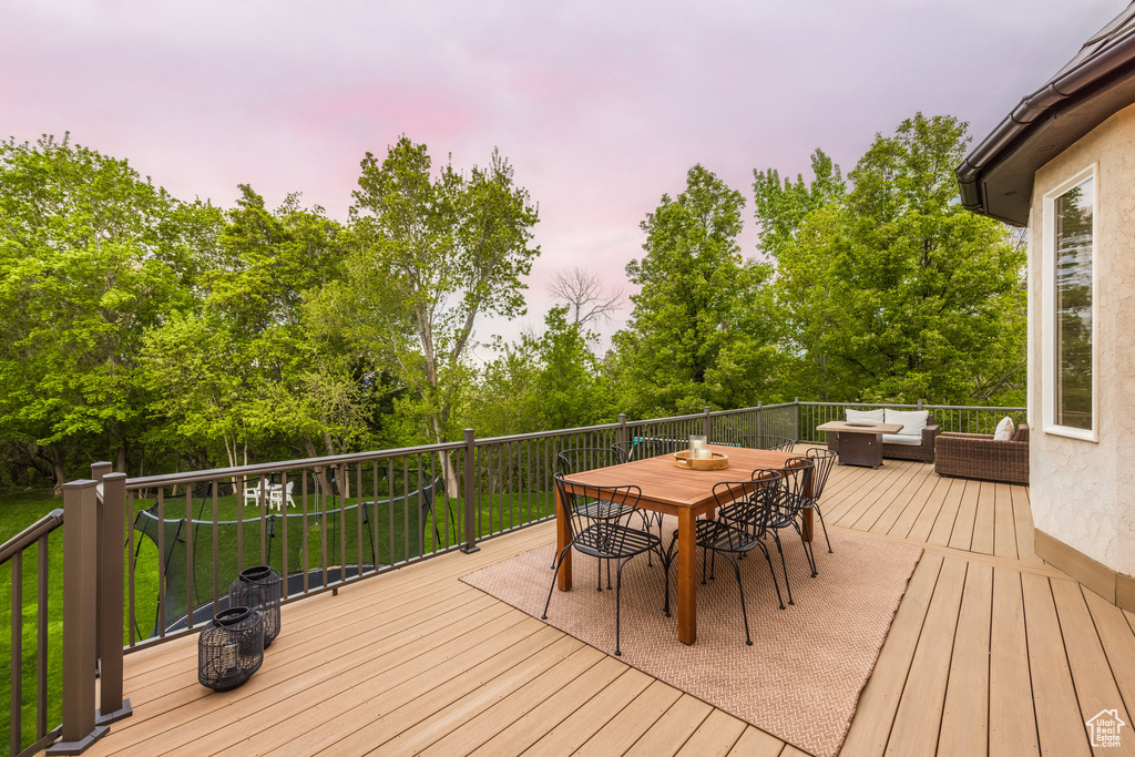 Deck at dusk featuring an outdoor hangout area and outdoor dining area