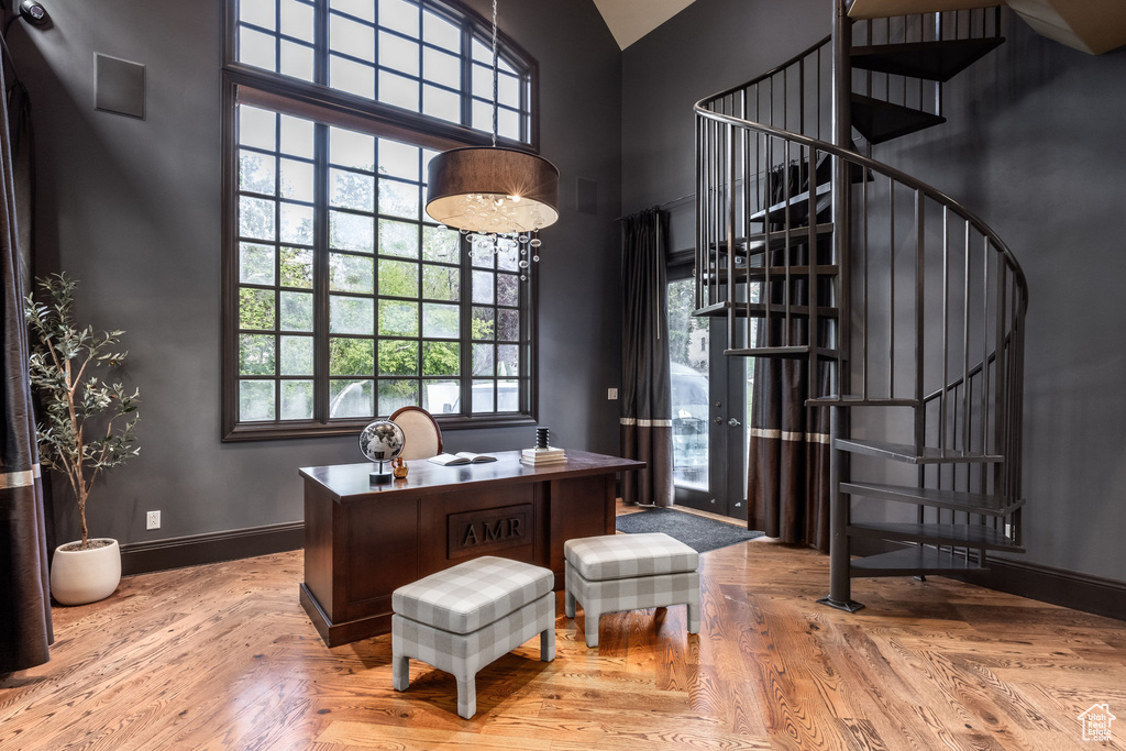 Office with baseboards and a towering ceiling