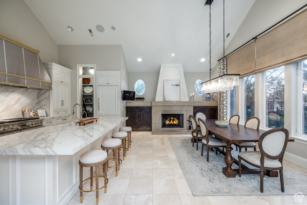 Dining area with a large fireplace, plenty of natural light, and vaulted ceiling