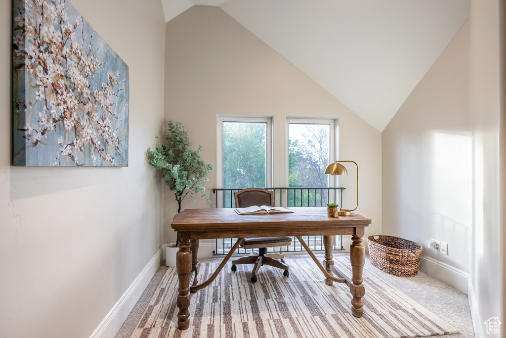 Home office featuring lofted ceiling, carpet, and baseboards