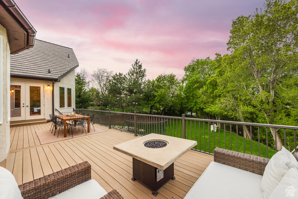 Wooden deck featuring an outdoor living space with a fire pit, a yard, french doors, and outdoor dining space