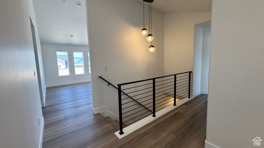 Staircase with wood finished floors and baseboards