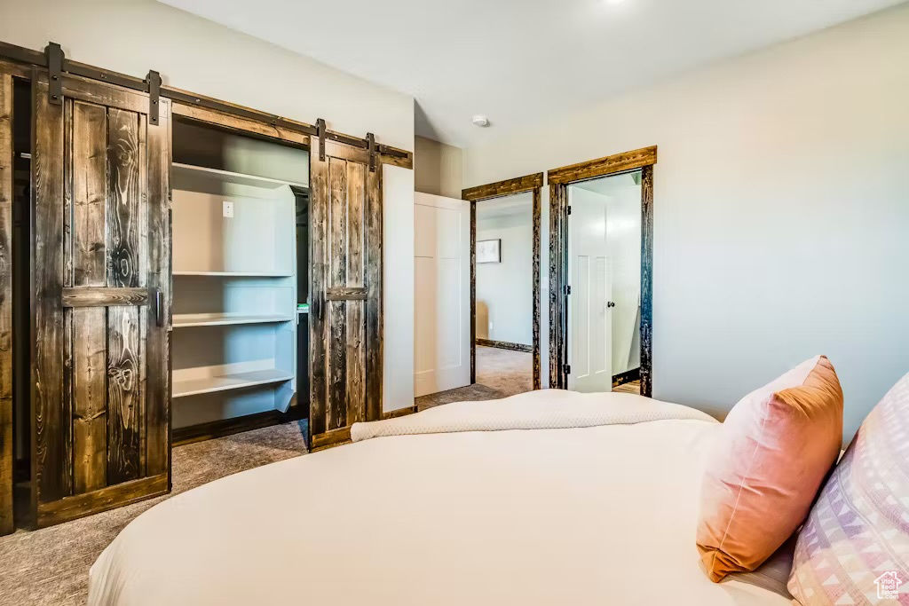 Carpeted bedroom with a barn door