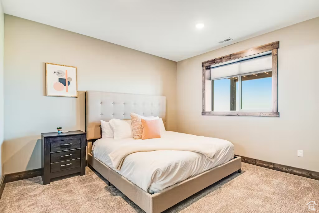 Carpeted bedroom with visible vents and baseboards