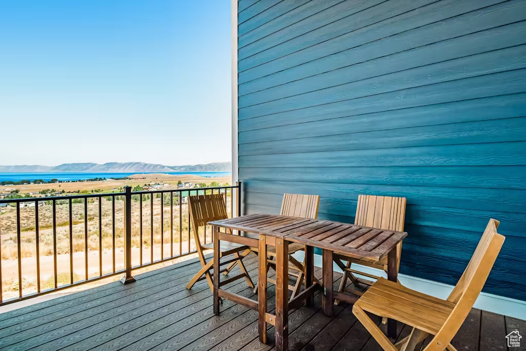Balcony with a water and mountain view and outdoor dining space