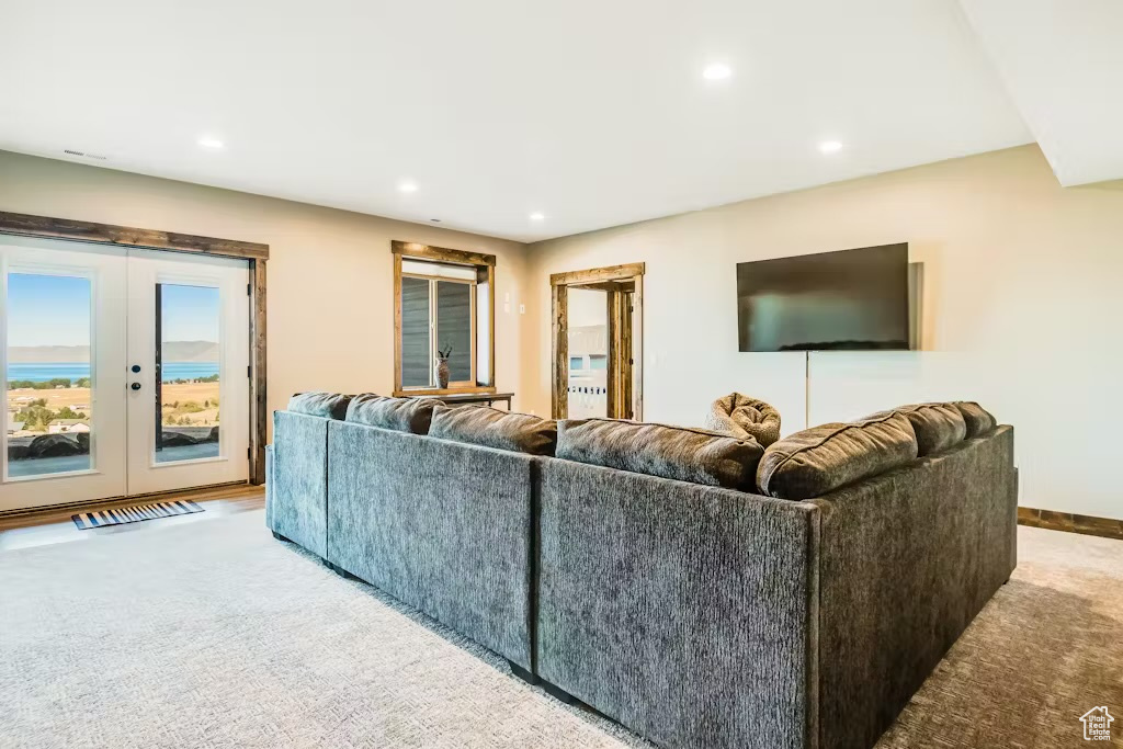 Carpeted living area with french doors and recessed lighting