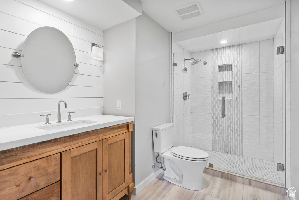 Bathroom featuring vanity, toilet, a shower stall, and visible vents