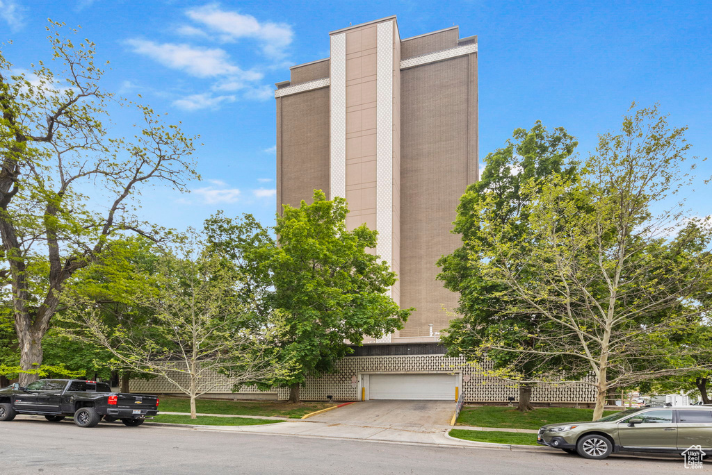 View of building exterior with concrete driveway and a garage