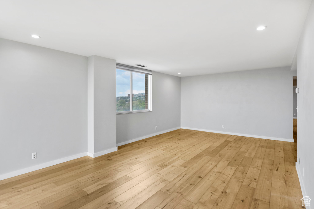 Unfurnished room featuring light wood-type flooring, baseboards, and recessed lighting