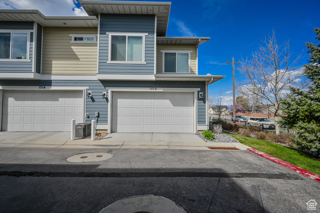 View of front of house featuring cooling unit and an attached garage