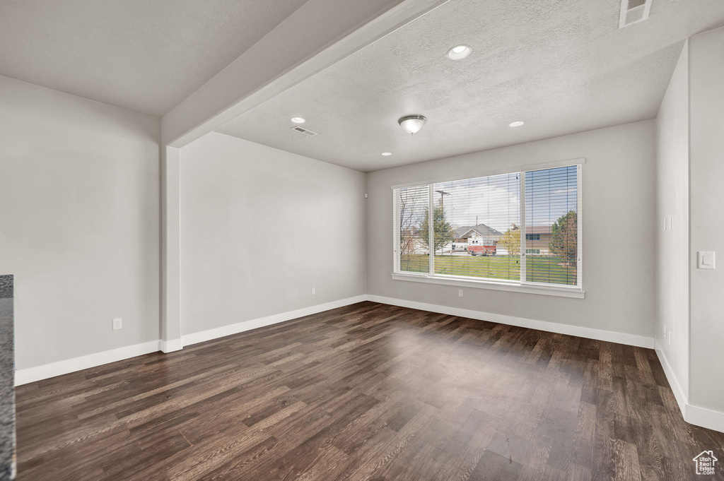 Spare room with recessed lighting, a textured ceiling, baseboards, dark wood finished floors, and visible vents