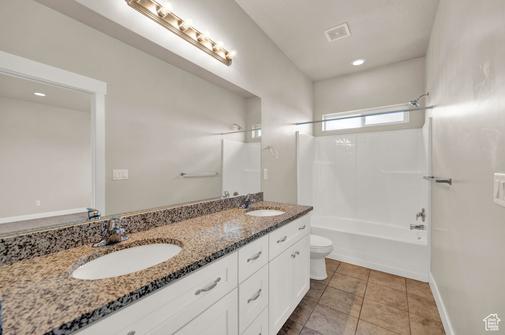 Bathroom with a sink, double vanity, toilet, and visible vents