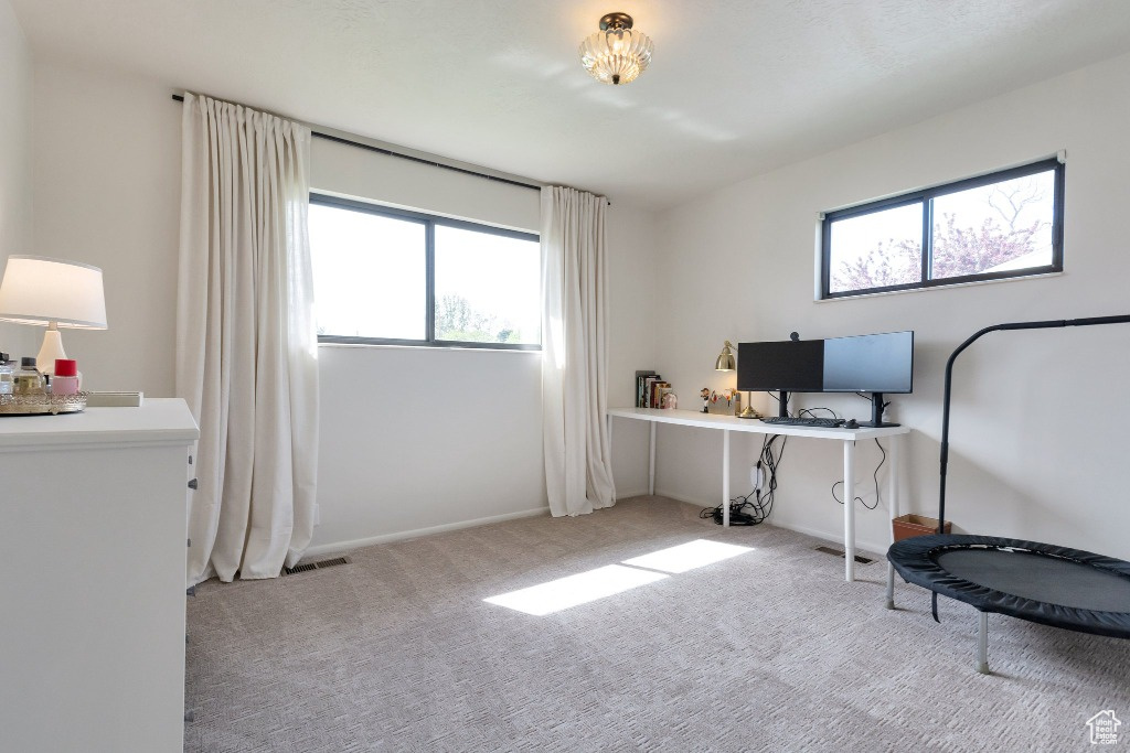 Carpeted office space featuring visible vents and baseboards