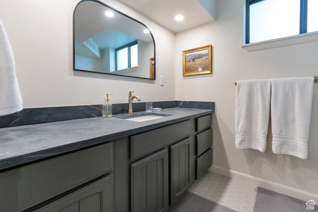 Bathroom featuring baseboards, vanity, and recessed lighting