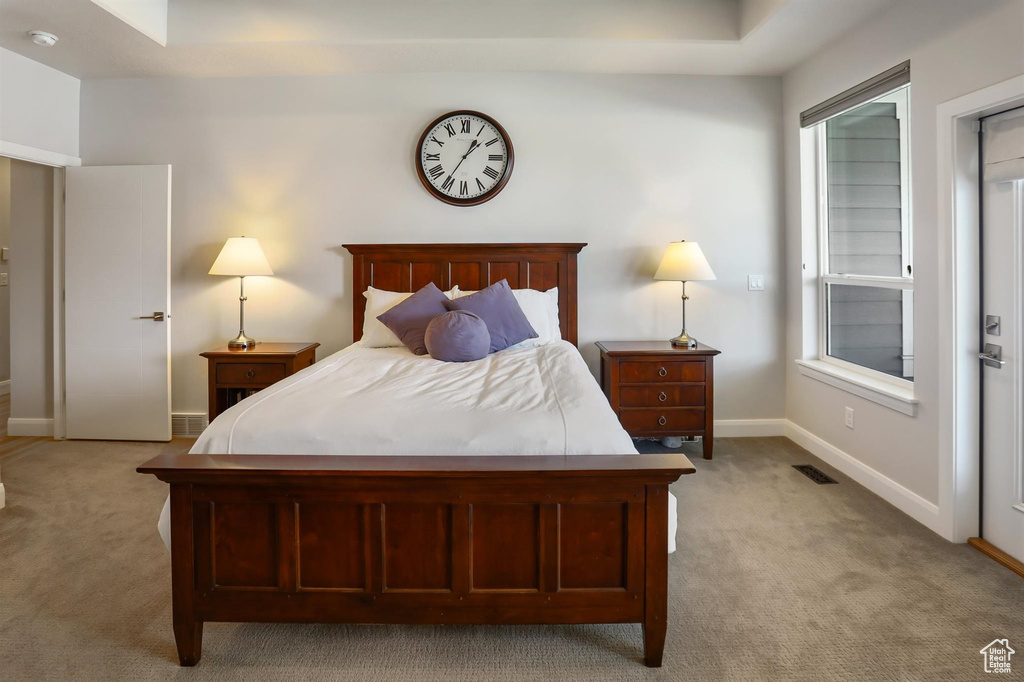Bedroom featuring baseboards, visible vents, and light colored carpet