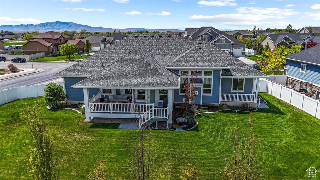 Back of house with a yard, roof with shingles, a residential view, and covered porch