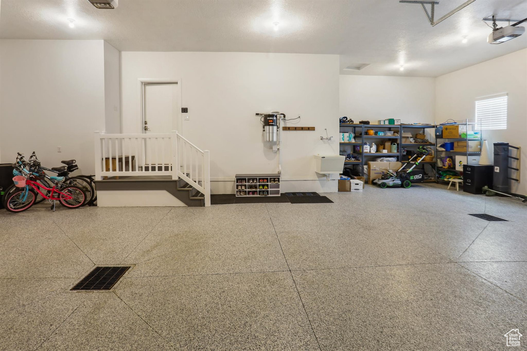 Garage featuring visible vents and a garage door opener