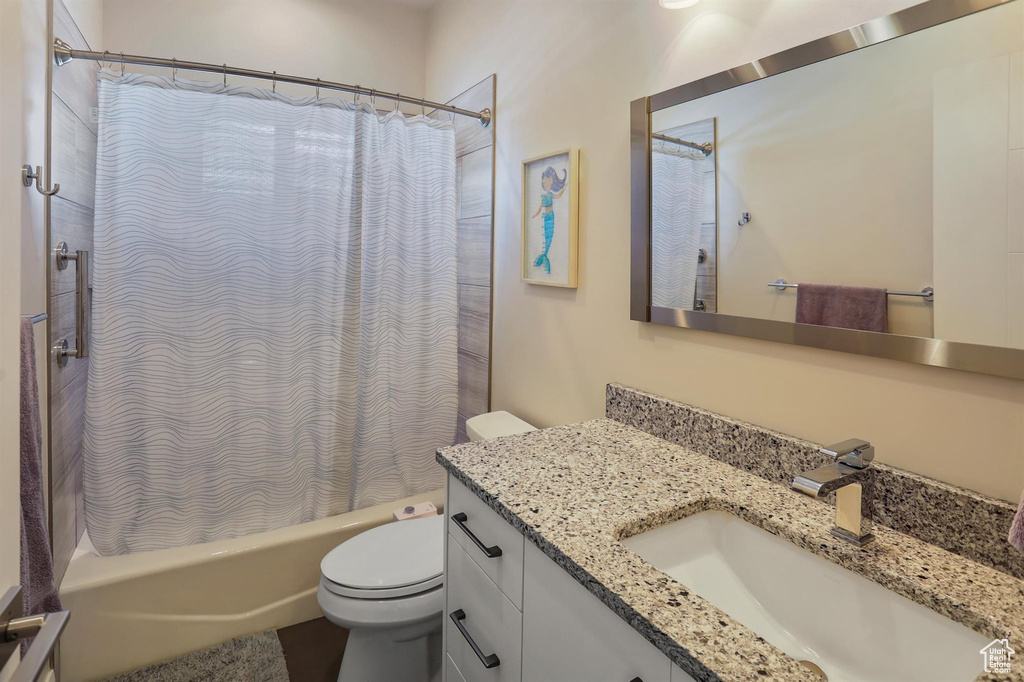 Full bathroom featuring vanity, toilet, and shower / bath combination with curtain
