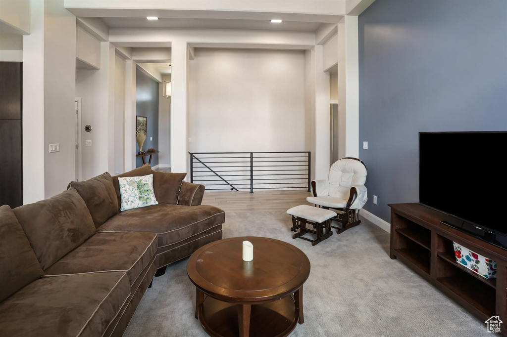 Carpeted living area with baseboards and recessed lighting