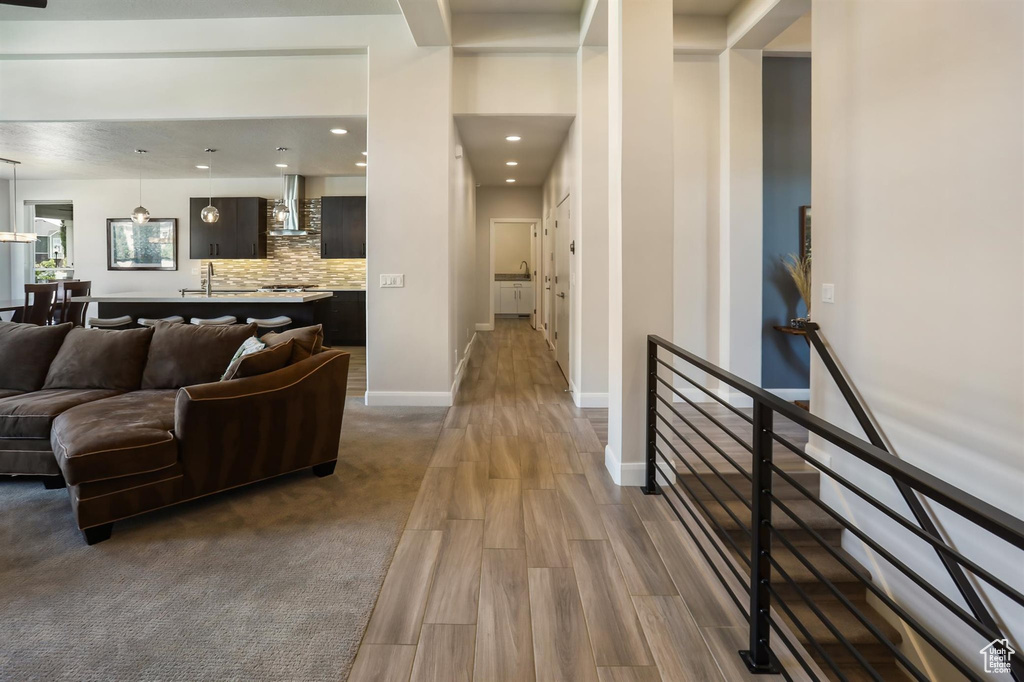 Living area with wood finished floors, baseboards, and recessed lighting