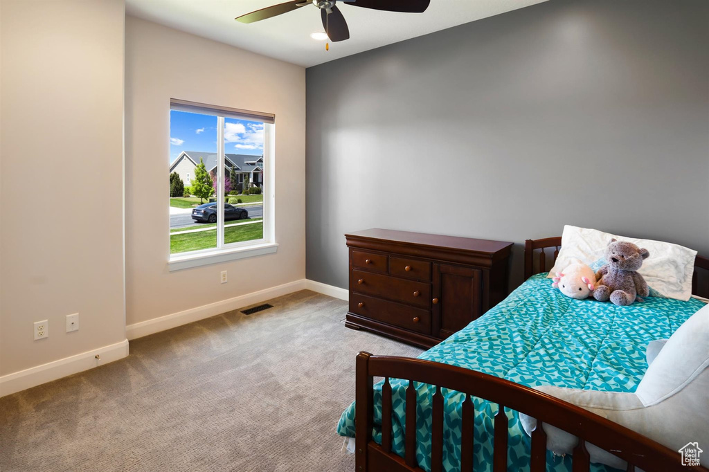 Bedroom featuring light colored carpet, baseboards, a ceiling fan, and visible vents
