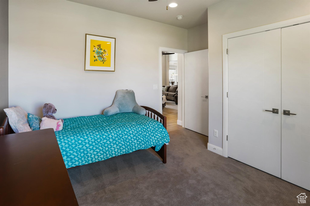 Carpeted bedroom with a closet and baseboards