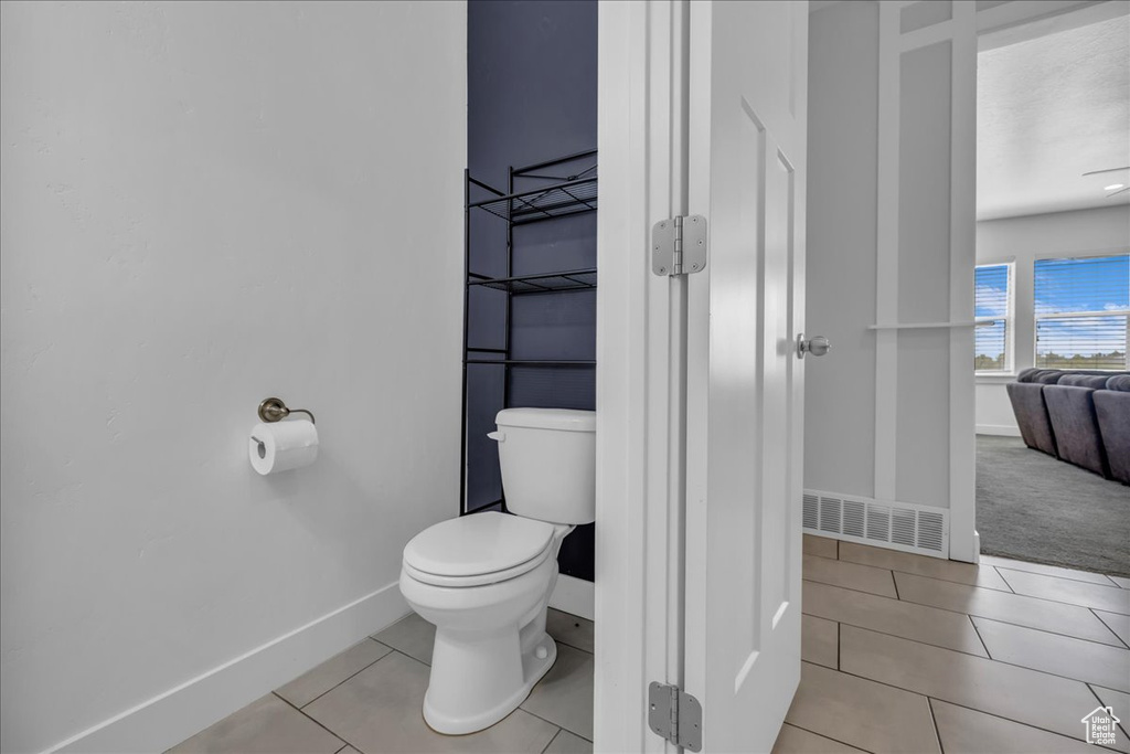 Bathroom with tile patterned flooring, toilet, baseboards, and visible vents