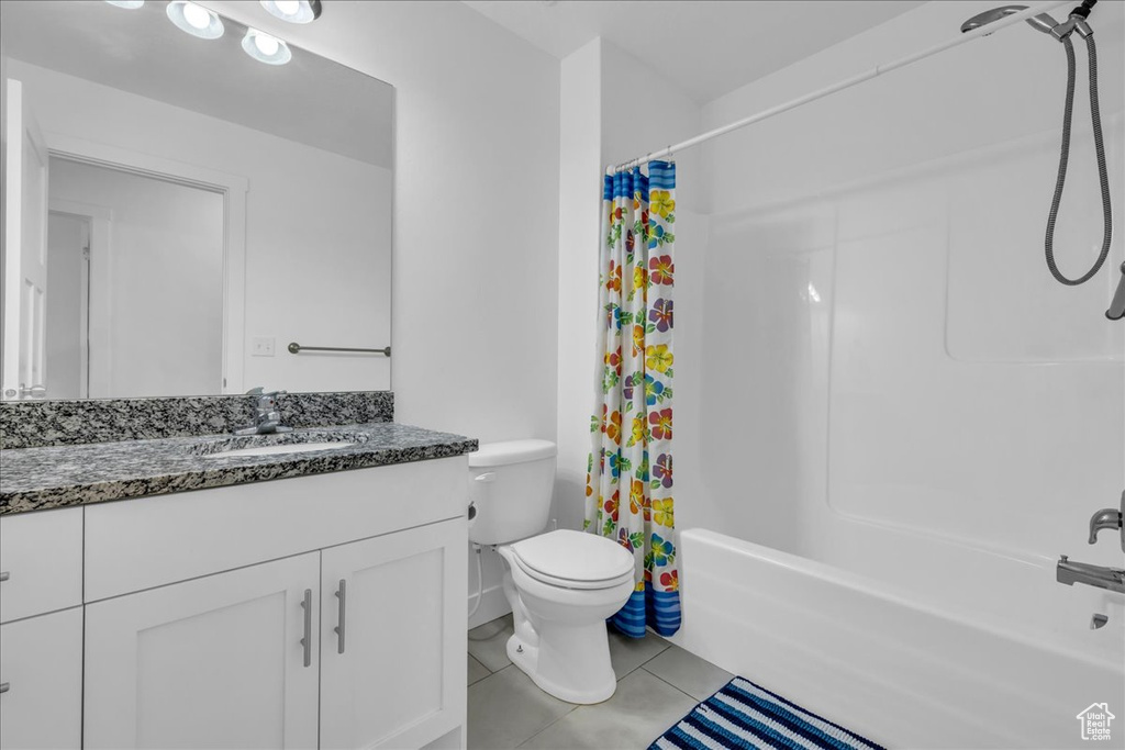 Full bathroom featuring toilet, shower / tub combo with curtain, tile patterned floors, and vanity
