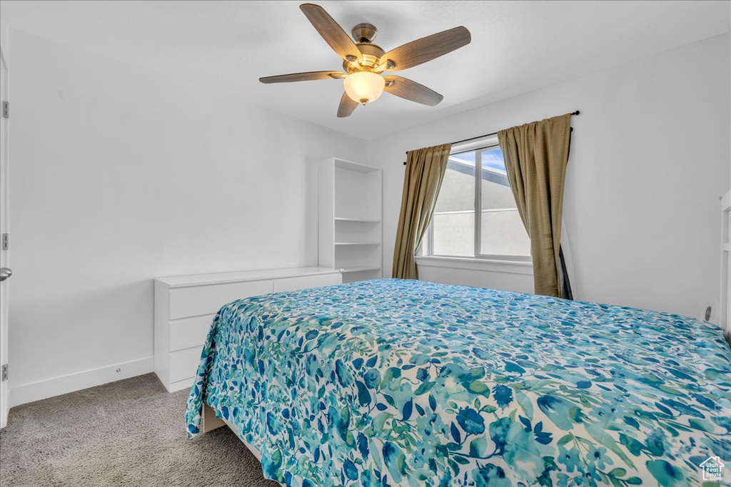 Bedroom featuring baseboards, carpet flooring, and ceiling fan