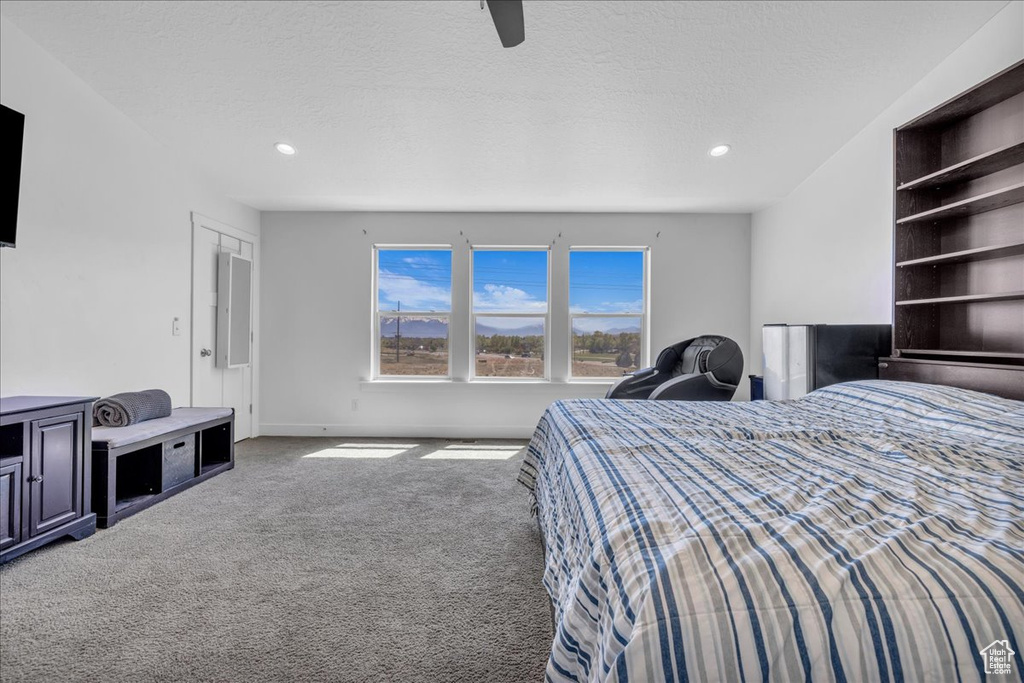Carpeted bedroom with ceiling fan, a textured ceiling, baseboards, and recessed lighting
