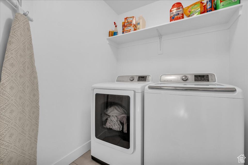 Washroom with washing machine and dryer, baseboards, and laundry area