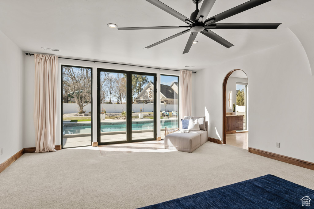 Interior space with arched walkways, carpet floors, baseboards, and recessed lighting