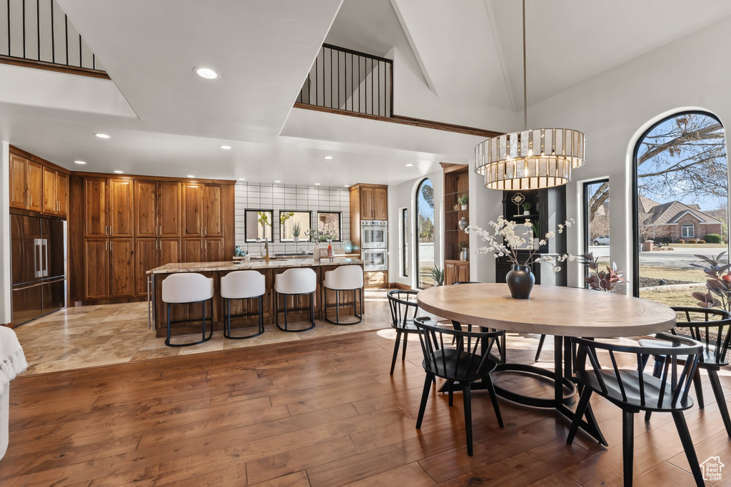 Dining area featuring light wood-style floors, plenty of natural light, a notable chandelier, and recessed lighting