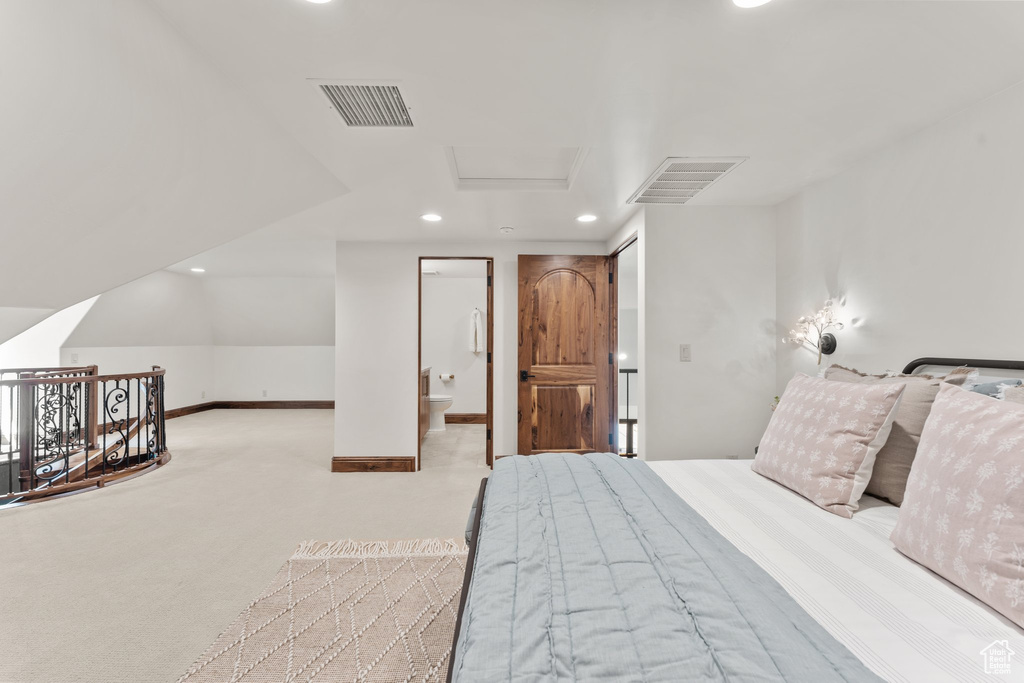 Carpeted bedroom featuring recessed lighting, visible vents, ensuite bathroom, attic access, and baseboards