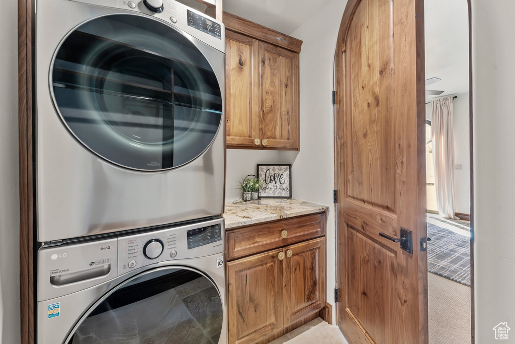 Laundry room with cabinet space and stacked washer / drying machine