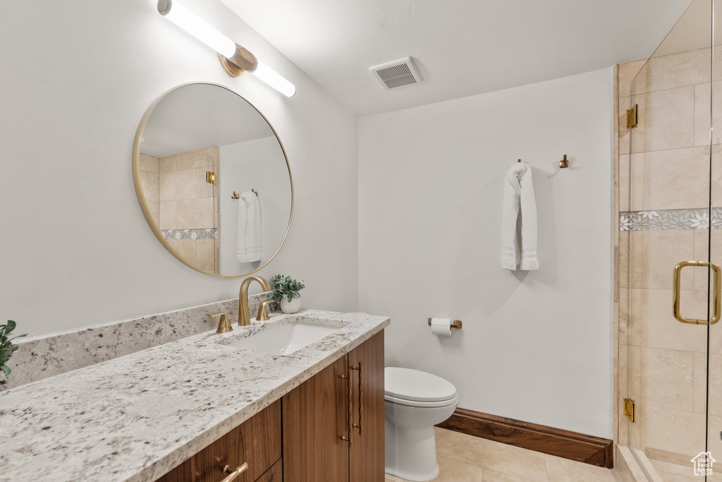 Bathroom with a stall shower, baseboards, visible vents, toilet, and vanity
