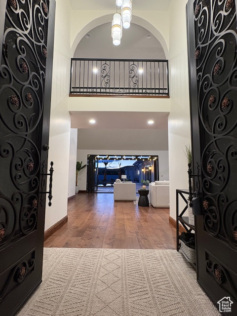 Entryway with baseboards, wood finished floors, and a towering ceiling