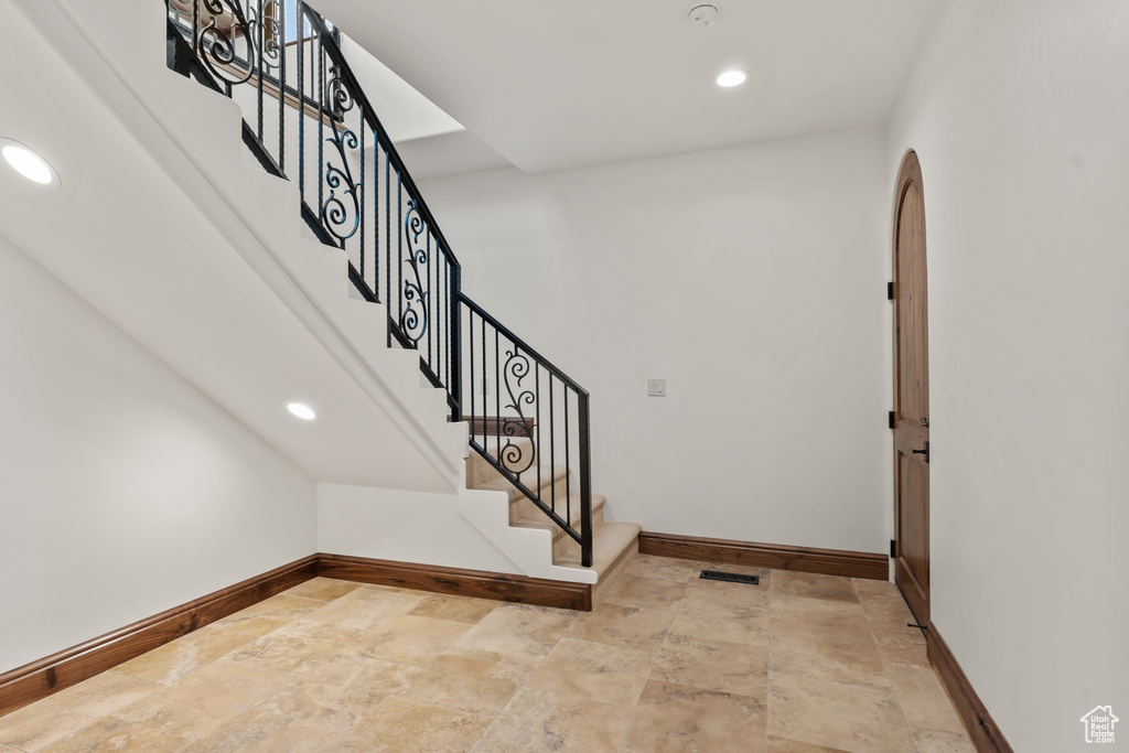 Foyer entrance with stone finish flooring, stairs, baseboards, and recessed lighting