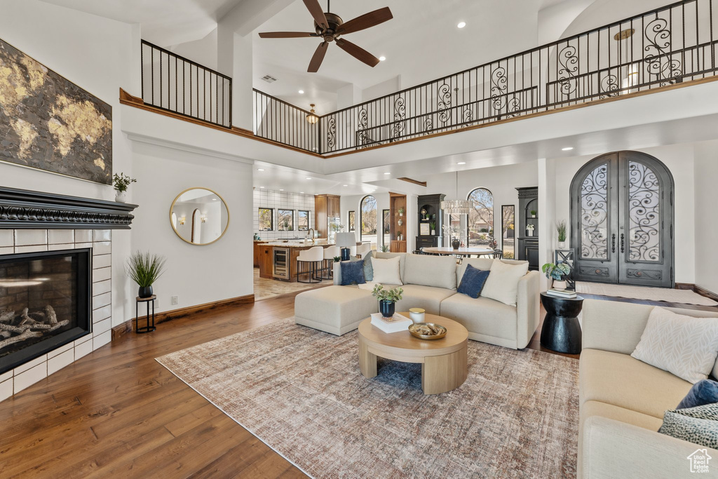 Living area with french doors, recessed lighting, wood-type flooring, a tile fireplace, and baseboards