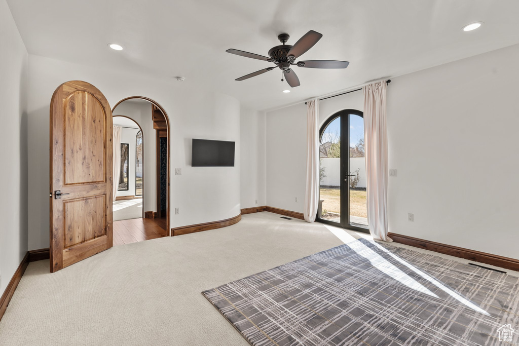 Carpeted spare room with baseboards, arched walkways, and recessed lighting