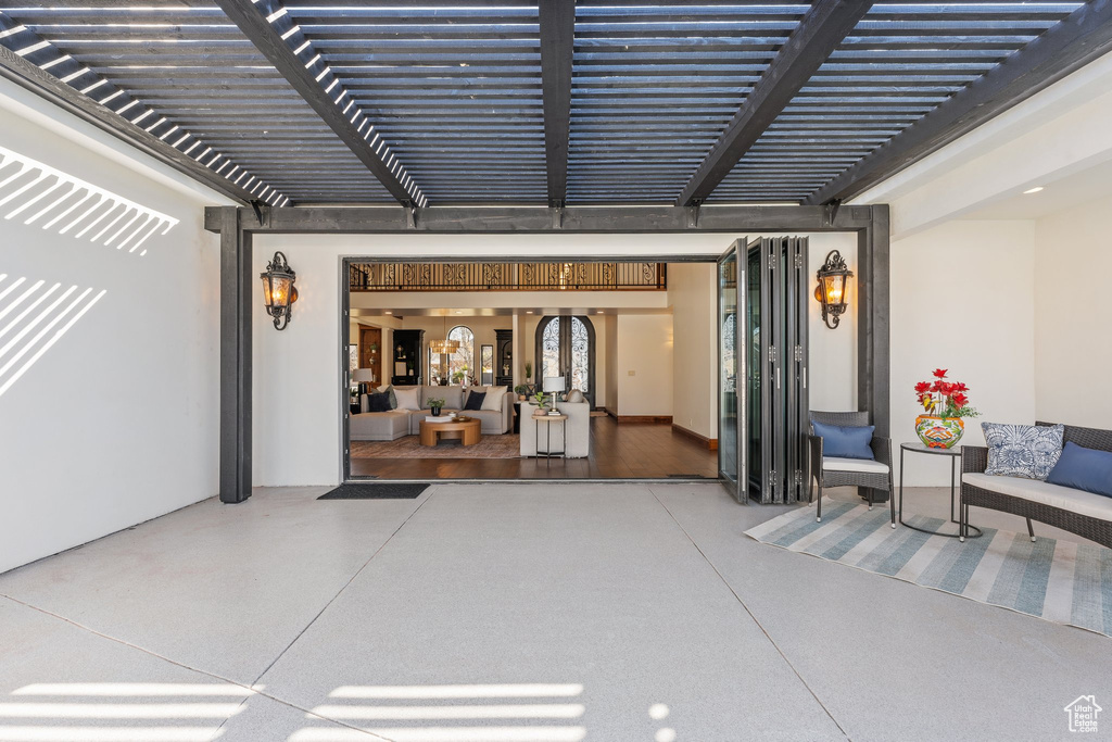 Doorway to property featuring a patio area and a pergola